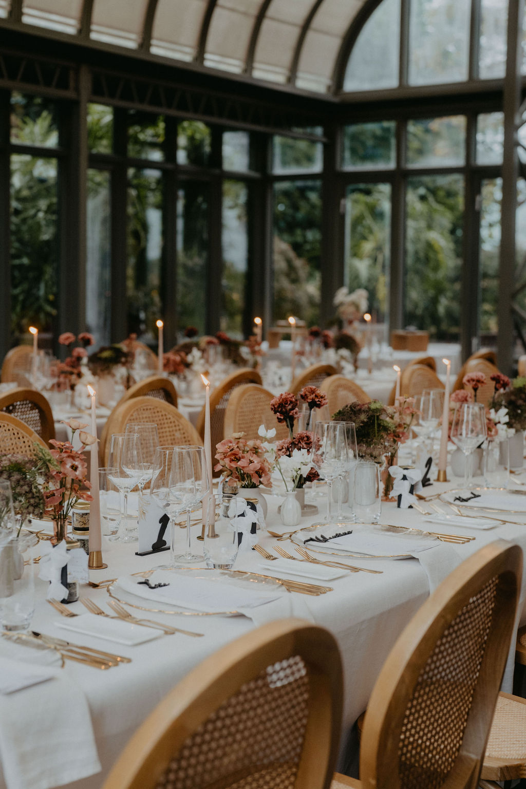 Home 41 Elegante Hochzeitstische mit Kerzen, Blumen und nummerierten Tischkarten in einem gläsernen Raum - die perfekte Inspiration für Ihre Hochzeitsplanung in der Schweiz.
