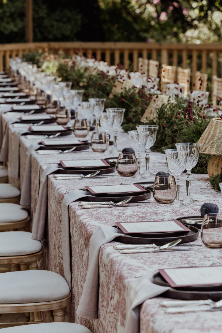 Eleganter Esstisch im Freien mit Gläsern, Tellern und floralen Tafelaufsätzen auf mit Leinen gedeckten Tischen - perfekt für einen Schweizer oder italienischen Hochzeitsplaner, der zeitlosen Stil sucht, Corporate Event Schweiz, Firmenevent
