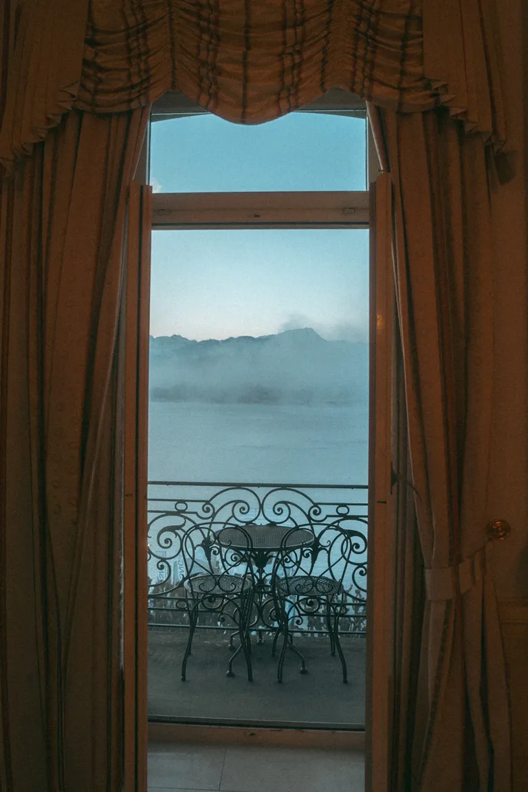 Ein Balkon mit Tisch und Stühlen und Blick auf einen nebelverhangenen See – ideal für eine Hochzeit in der Schweiz.