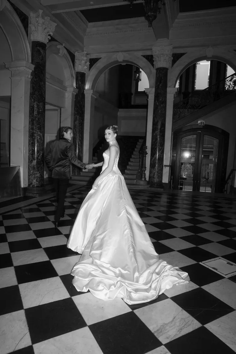 Bei einer luxuriösen Hochzeit in der Schweiz führt eine Braut in einem weißen Kleid einen Mann über einen Fliesenboden. Luxury Wedding Planner, Zurich, The WES, Switzerland, Schweiz, Lara Flueckiger, Grand Hotel National, Luzern