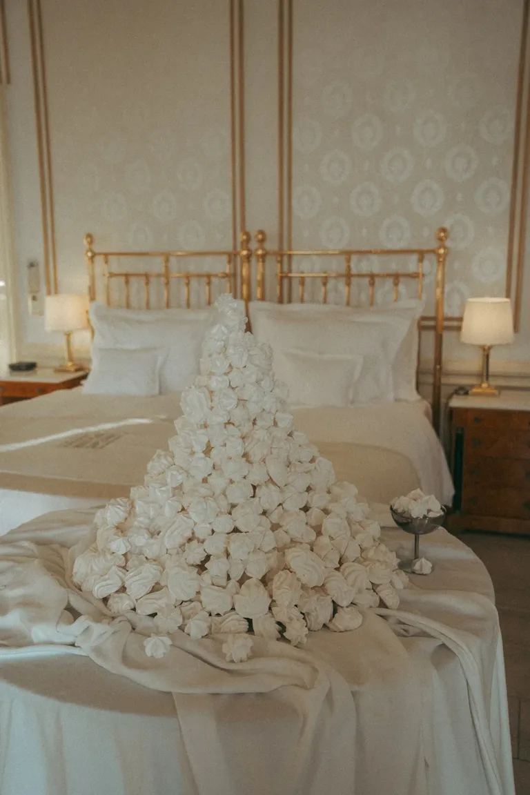 Eine große Pyramide aus weißen Baiserkeksen, die von einem Luxus-Hochzeitsplaner in einem Schlafzimmer aufgebaut wurde.