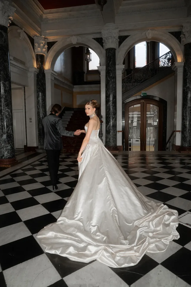 Bei einer luxuriösen Hochzeit in der Schweiz führt eine Braut in einem weißen Kleid einen Mann über einen Fliesenboden. Luxury Wedding Planner, Zurich, The WES, Switzerland, Schweiz, Lara Flueckiger, Grand Hotel National, Luzern