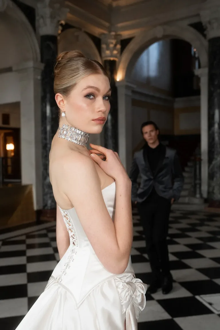 Eine Frau in einem weißen Korsettkleid und einem Kristall-Halsband, im Hintergrund ein luxuriöser Hochzeitsplaner, Luxury Wedding Planner, Zurich, The WES, Switzerland, Schweiz, Lara Flueckiger, Grand Hotel National, Luzern