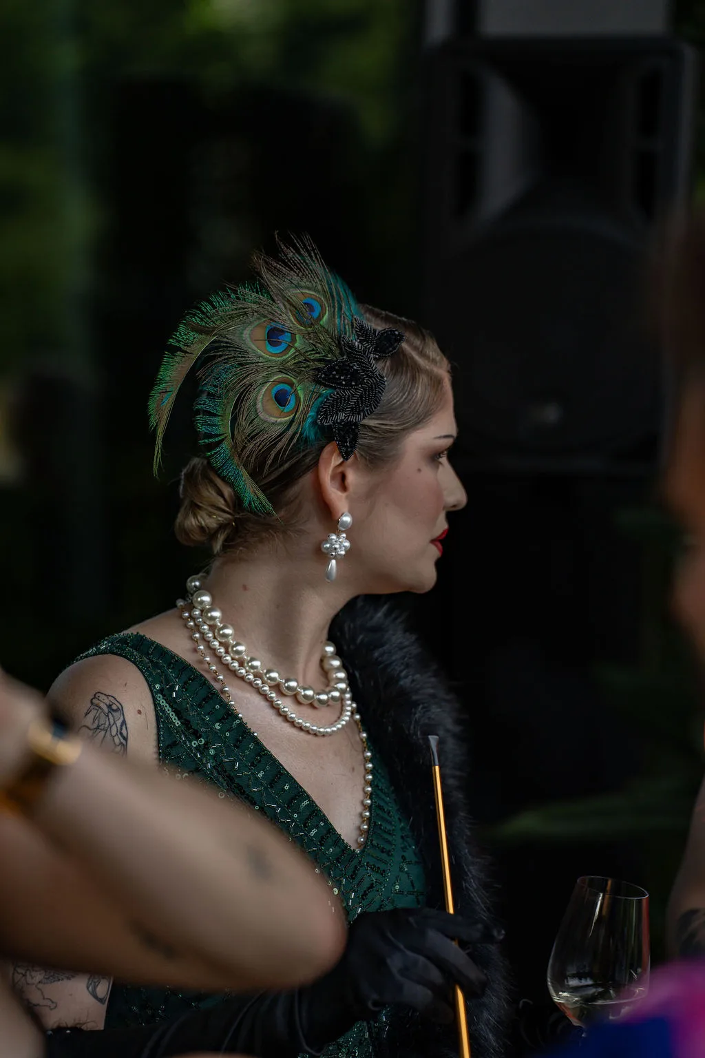 Frau in Kleidung im Stil der 1920er Jahre mit Pfauenfedern – perfekt für glamouröse Firmenveranstaltungen in der Schweiz. nea Baummuseum Rapperswil, Private Event Schweiz