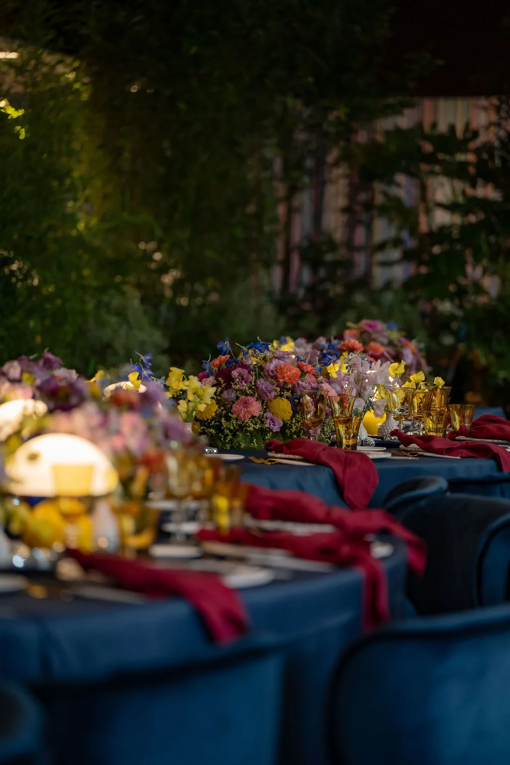 Eleganter Bankettsaal mit blauen Stühlen, ideal für Firmenveranstaltungen in der Schweiz, mit Blumendekorationen und sanfter Beleuchtung. Enea Baummmuseum Rapperswil, Private Event Schweiz, Eventplanner